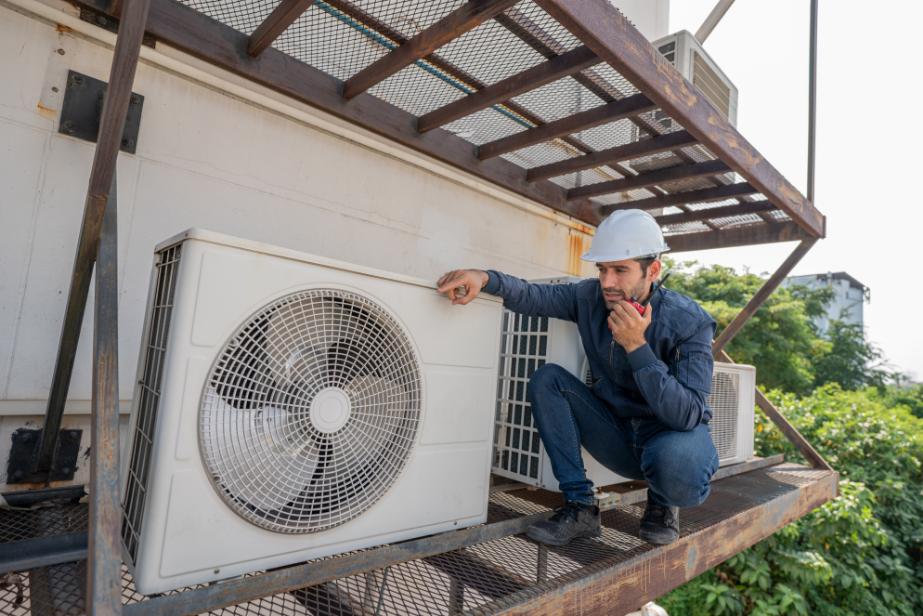Blitztek HVAC technician inspecting outdoor AC unit