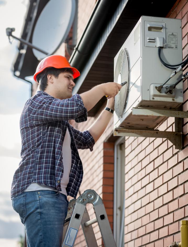 Blitztek HVAC technician servicing outdoor AC unit on ladder